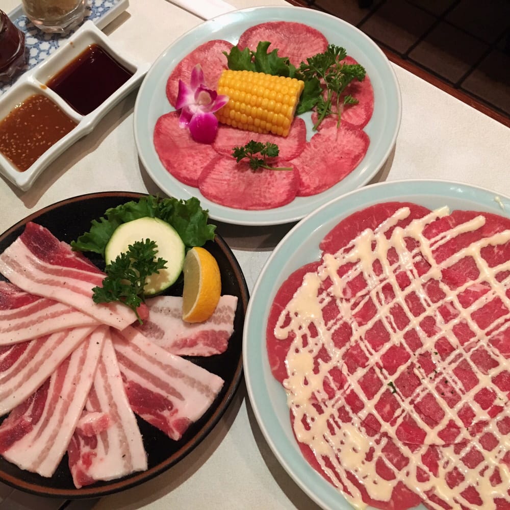 Full spread of yakiniku dishes, kimchi, and sides across the table